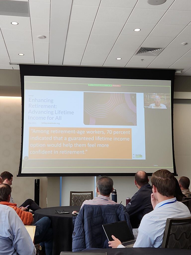 Audience members at the NAIFA Utah Symposium watch a presentation about guaranteed lifetime income and retirement confidence during a retirement planning session.